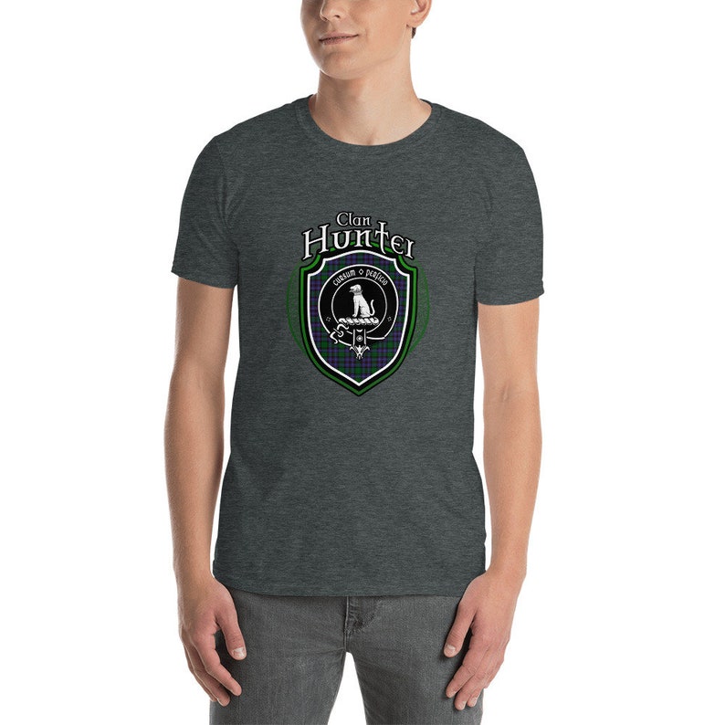 May include: A heather grey t-shirt with a white graphic of a clan crest. The crest features a dog, a sword, and the text "Clan Hunter" and "Cruach o' Fhiodh".