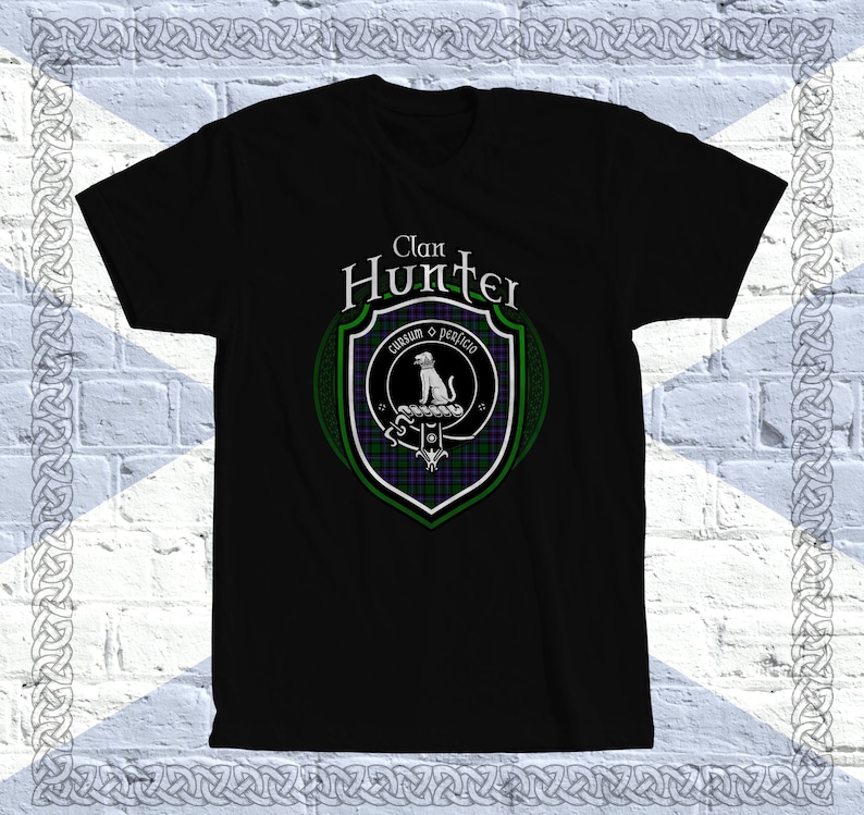 May include: Black t-shirt with a green and purple clan crest featuring a white dog and the text "Clan Hunter" and "Cunsum o perfido".