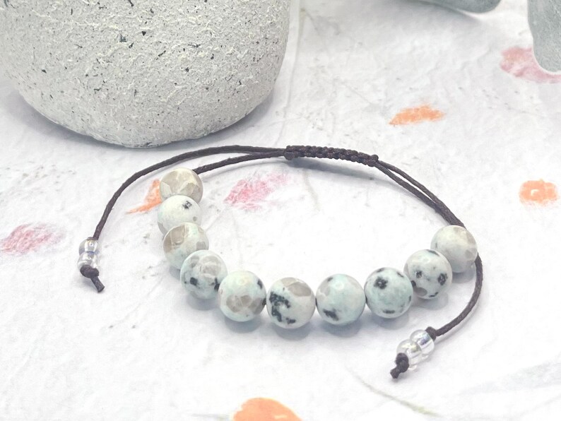 a Beautiful 10 Breaths Bracelet, featuring 10, 8mm stones that are a creamy light green speckled with dark and clear marks.  These stones are not highly polished, they are half matte, which add to their beauty.