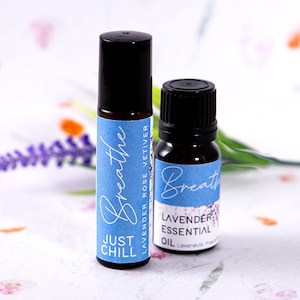 May include: Two small bottles of essential oil with blue and white labels. The labels say "Breathe" and "Lavender Essential Oil".