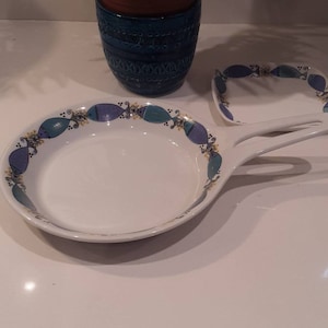Può includere: Due piatti da portata in ceramica bianca con disegni di pesci blu e verdi. Il piatto più grande ha un manico e il piatto più piccolo è quadrato.