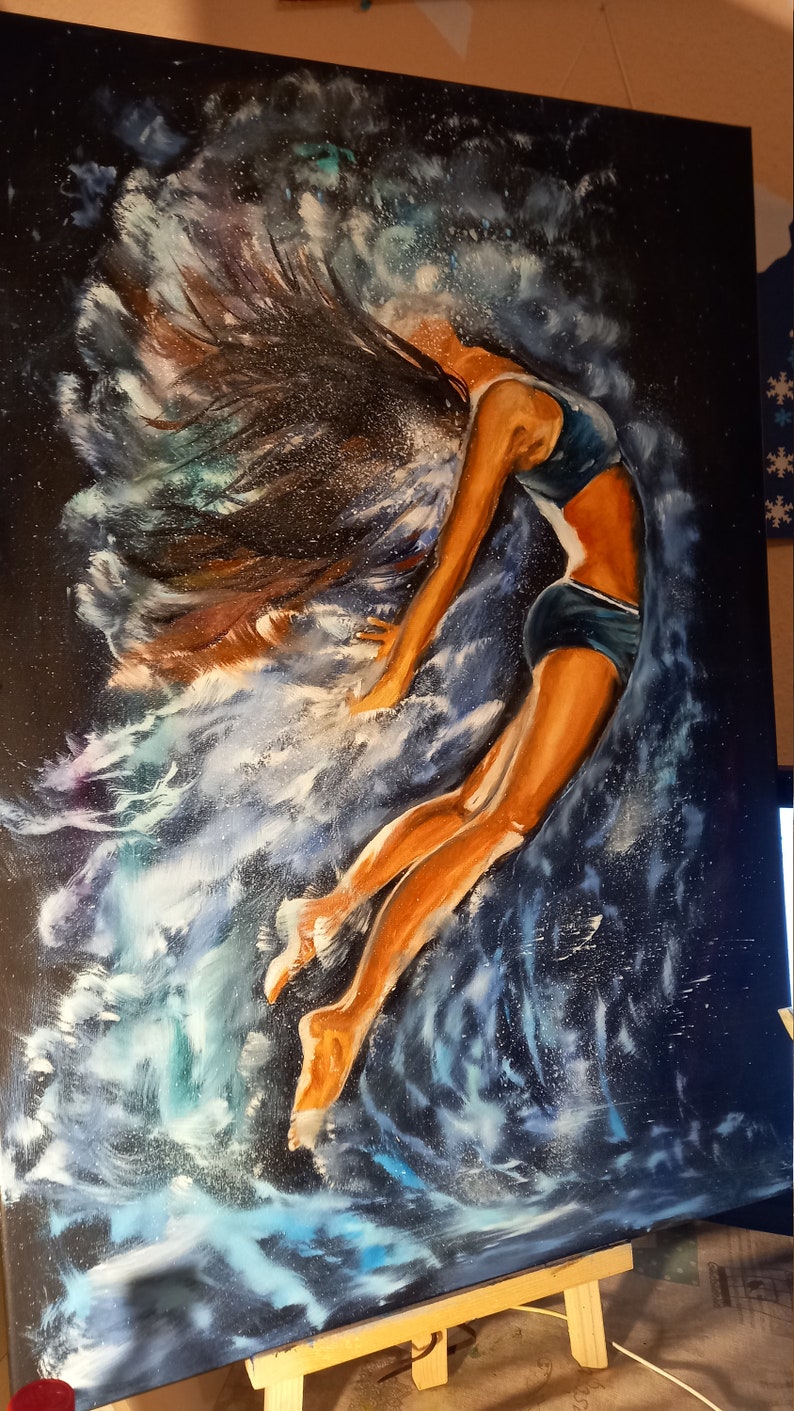 Puede incluir: Una pintura de una mujer con el pelo largo y oscuro, vestida con un traje de ba&ntilde;o azul, saltando a trav&eacute;s de una ola de agua. El fondo es azul oscuro con remolinos blancos y azules.
