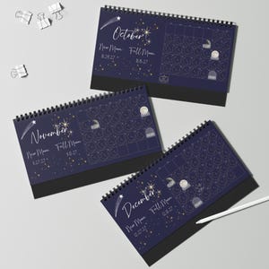 May include: Three spiral-bound desk calendars for October, November, and December 2027. Each dark blue page features celestial graphics, moon phase dates, and a grid layout. The calendars include text for New Moon and Full Moon dates.