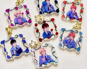 May include: Set of seven colorful acrylic charms featuring anime characters with rose and vine details. Each charm has a gold loop for attaching to a keychain or bag.