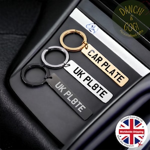 May include: Three silver keyrings with black, silver, and gold metal tags. The tags are engraved with "UK PL8TE" and "CAR PLATE".