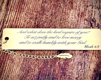 May include: Gold bookmark with a chain and a feather charm. The bookmark features the text "And what does the lord require of you? To act justly and to love mercy and to walk humbly with your God. Micah 6:8"