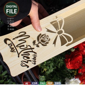 May include: Wooden box with a cut-out design for a flower arrangement. The box has a bow and a rose design with the text "Happy Mother's Day".