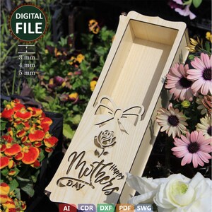 May include: A wooden box with a cut-out design of a rose, bow, and the text "Happy Mother's Day". The box is made for holding a single flower.