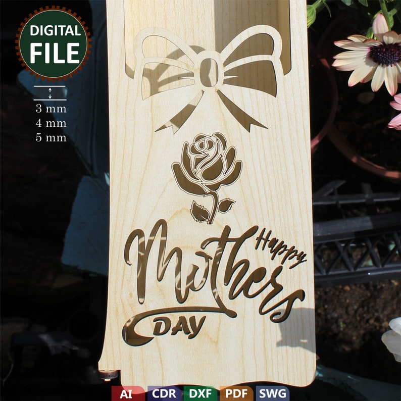 May include: A wooden cutout of a rose and a bow with the text "Happy Mothers Day" on a light brown background. The cutout is designed for laser cutting.