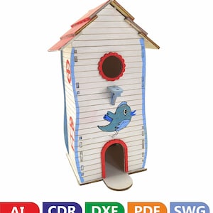 Puede incluir: Una casita de pájaros de madera pintada de blanco con detalles azules y rojos. La casita tiene una pequeña abertura para que los pájaros entren y una percha para que aterricen. Hay un pájaro azul pintado en la parte delantera de la casita.