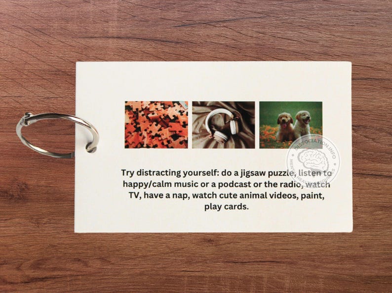 May include: A white card with a text message about distracting yourself with activities like doing a jigsaw puzzle, listening to music, watching TV, or playing cards. The card has three images: a jigsaw puzzle, headphones, and two puppies.