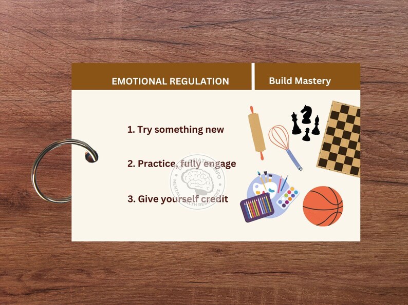 May include: A brown card with the text "Emotional Regulation" and "Build Mastery" on it. The card lists three steps for emotional regulation: "Try something new", "Practice, fully engage", and "Give yourself credit". The card also features illustrations of a rolling pin, whisk, paintbrushes, a chessboard, and a basketball.