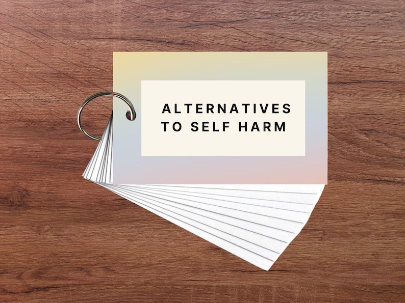 May include: A set of cards with a rainbow gradient background. The top card has the text "Alternatives to Self Harm" in black.