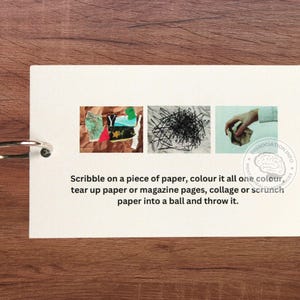 May include: A white card with instructions for a paper art activity. The card has three images: a collage of paper scraps, a pile of black paper clips, and a hand crumpling a piece of paper. The text reads: "Scribble on a piece of paper, colour it all one colour, tear up paper or magazine pages, collage or scrunch paper into a ball and throw it."