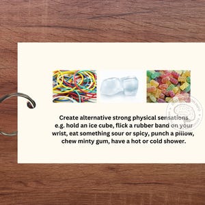 May include: A card with three images and text. The images show a pile of colourful rubber bands, two ice cubes, and a pile of colourful gummy sweets. The text reads "Create alternative strong physical sensations e.g. hold an ice cube, flick a rubber band on your wrist, eat something sour or spicy, punch a pillow, chew minty gum, have a hot or cold shower."