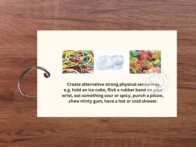 May include: A card with three images and text. The images show a pile of colourful rubber bands, two ice cubes, and a pile of colourful gummy sweets. The text reads "Create alternative strong physical sensations e.g. hold an ice cube, flick a rubber band on your wrist, eat something sour or spicy, punch a pillow, chew minty gum, have a hot or cold shower."