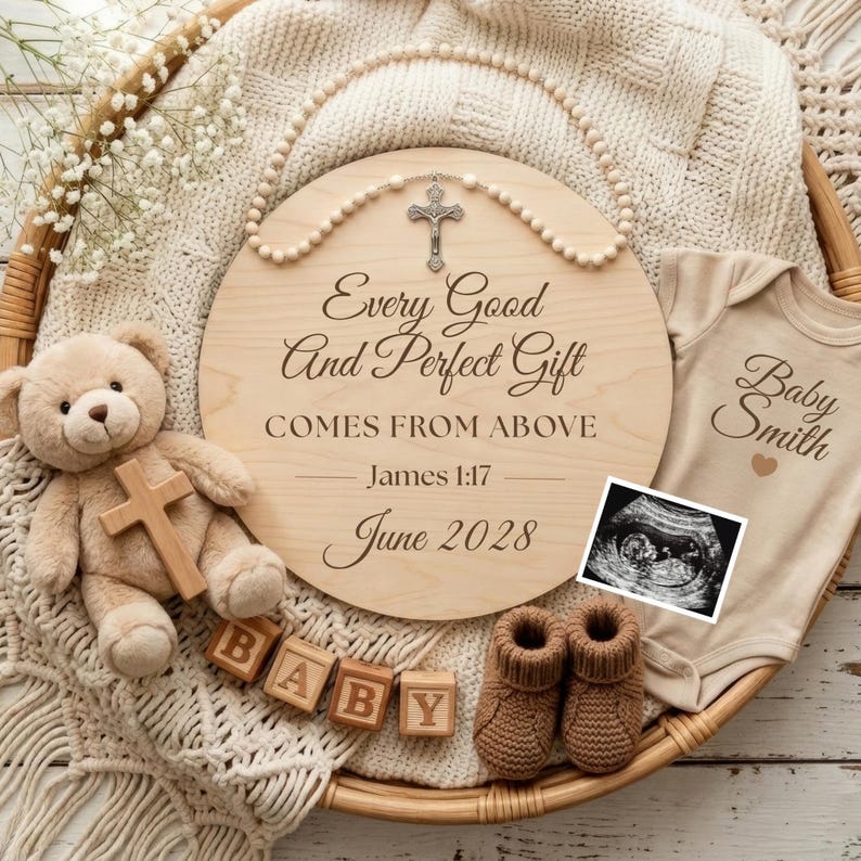 Puede incluir: Un letrero de madera con el texto "Every Good And Perfect Gift COMES FROM ABOVE James 1:17 June 2028" est&aacute; rodeado por un rosario, un oso de peluche con una cruz, bloques de beb&eacute;, un body, botines de beb&eacute; y una imagen de ultrasonido.