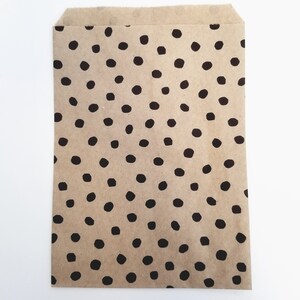 May include: A brown paper bag with a black polka dot pattern.