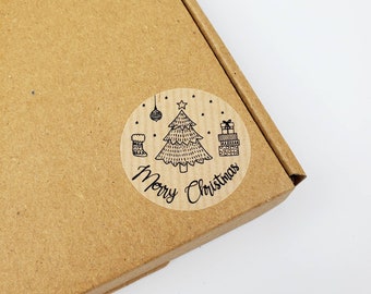 May include: A round, clear sticker with a black and white illustration of a Christmas tree, ornaments, a stocking, and presents. The text "Merry Christmas" is written below the illustration.