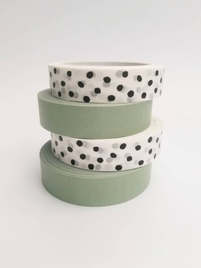 May include: Four rolls of washi tape, two are green and two are white with black and gray polka dots.