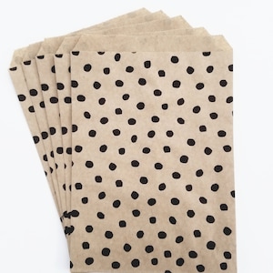 May include: A stack of brown paper bags with a black polka dot pattern.
