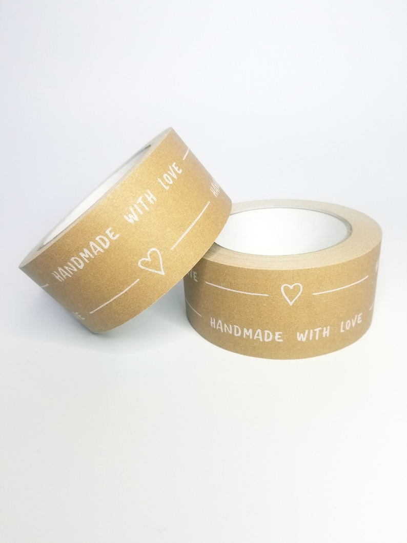 May include: Two rolls of brown paper tape with white text that reads "Handmade with Love" and a small heart symbol.