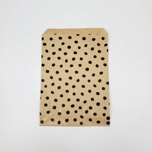 May include: A brown paper bag with a black polka dot pattern.