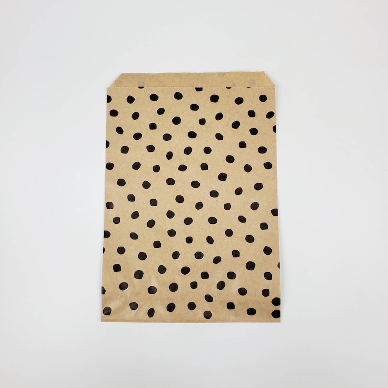 May include: A brown paper bag with a black polka dot pattern.