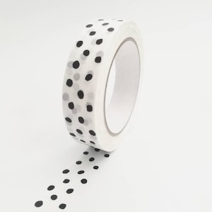 May include: A roll of white washi tape with a black polka dot pattern. The tape is unrolled and the polka dots are visible.