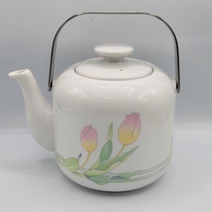May include: White ceramic teapot with a stainless steel handle and a floral design featuring pink and yellow tulips.