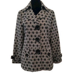 May include: A black and white floral patterned coat. The coat features a collared neckline, three large black buttons down the front, and two smaller buttons on the cuffs. The coat is displayed on a black mannequin.