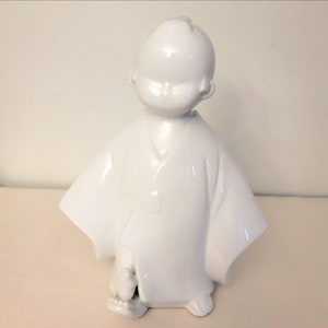 A Japanes Meiji Period Hirado Porcelain Figurine a boy with bird