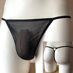Puede incluir: Ropa interior de malla negra con una fina correa negra y un detalle de anillo plateado.