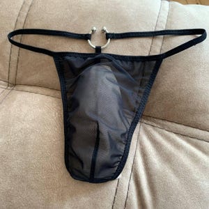 May include: Black sheer mesh thong with a silver ring detail.