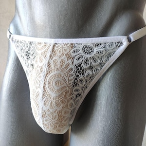 Puede incluir: Ropa interior de encaje blanco con un delicado patrón floral.