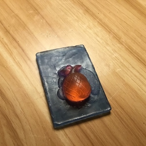 May include: A clear blue soap bar with a red and orange pineapple design.