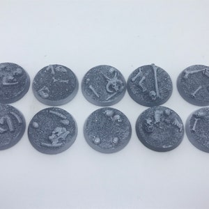 May include: Ten gray plastic round bases with various bone and skull designs. The bases are for miniature wargaming.