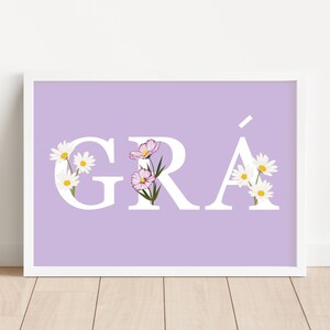 May include: A light purple printable wall art print with the word "GR&Aacute;" in white letters with white flowers and pink flowers in the letters.