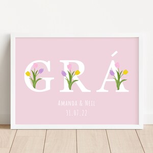 May include: A pink printable art print with the word "GR&Aacute;" in white letters with colourful tulips in the letters. The text "Amanda & Neil 31.07.22" is below the word.