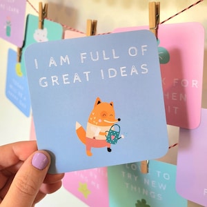 May include: A blue card with a white fox holding a watering can. The card says "I am full of great ideas".