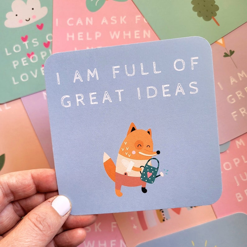 May include: A blue card with a white border and the text "I am full of great ideas" in white. A cartoon fox with a watering can is illustrated on the card.