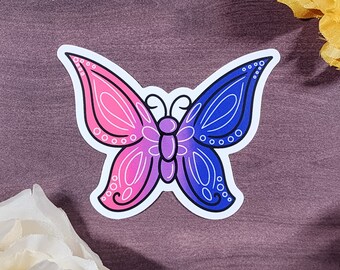 Könnte beinhalten: Ein Aufkleber mit einem Schmetterling mit rosa, lila und blauen Flügeln. Der Schmetterling ist mit einer weißen Umrandung versehen.