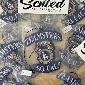 Puede incluir: Una colección de ambientadores para coche con el logotipo de los Dodgers de Los Ángeles y la frase "So. Cal.". Los ambientadores son azules y dorados con un aroma a hielo negro. Los ambientadores están envasados en bolsas de plástico transparentes.