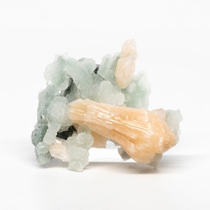 May include: A cluster of light green and orange crystals. The crystals are arranged in a random pattern and have a rough, natural texture.