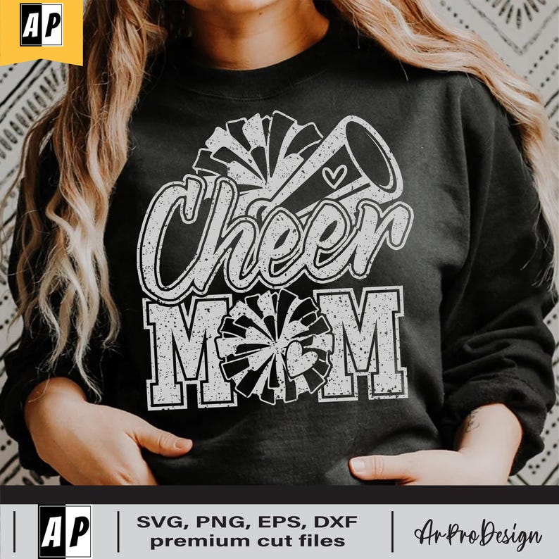Może przedstawiać: Czarna bluza z białym nadrukiem graficznym z napisem "Cheer Mom" z pomponem cheerleaderki i megafonem.