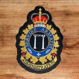 May include: An embroidered patch featuring a central blue circle with two white pillars and the text POPULIS, surrounded by gold maple leaves. Above is a red and gold crown, and below is a gold banner with the text ADMINISTRATION.