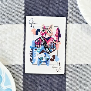 May include: A playing card featuring a colourful illustration of two cats. The card is a Jack of Clubs and the suit is written as "Clean" instead of "Clubs".