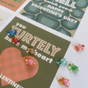 May include: Valentine's Day cards with turtle and heart designs. One card reads "You turtley have my heart" with a pink and orange heart. Other cards have turtle and shell graphics with Valentine's Day greetings. Small, colorful turtle-shaped embellishments are scattered around.