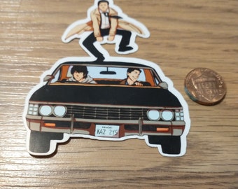 May include: A black car with two figures inside and a third figure jumping on top of the car. The car has a Kansas license plate that reads "KAZ 2YS".