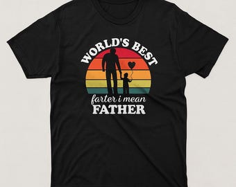 Puede incluir: Camiseta negra con un diseño gráfico que presenta la silueta de un padre y un niño sosteniendo un globo en forma de corazón, sobre un atardecer. El texto dice "WORLD'S BEST" y "farter i mean FATHER".